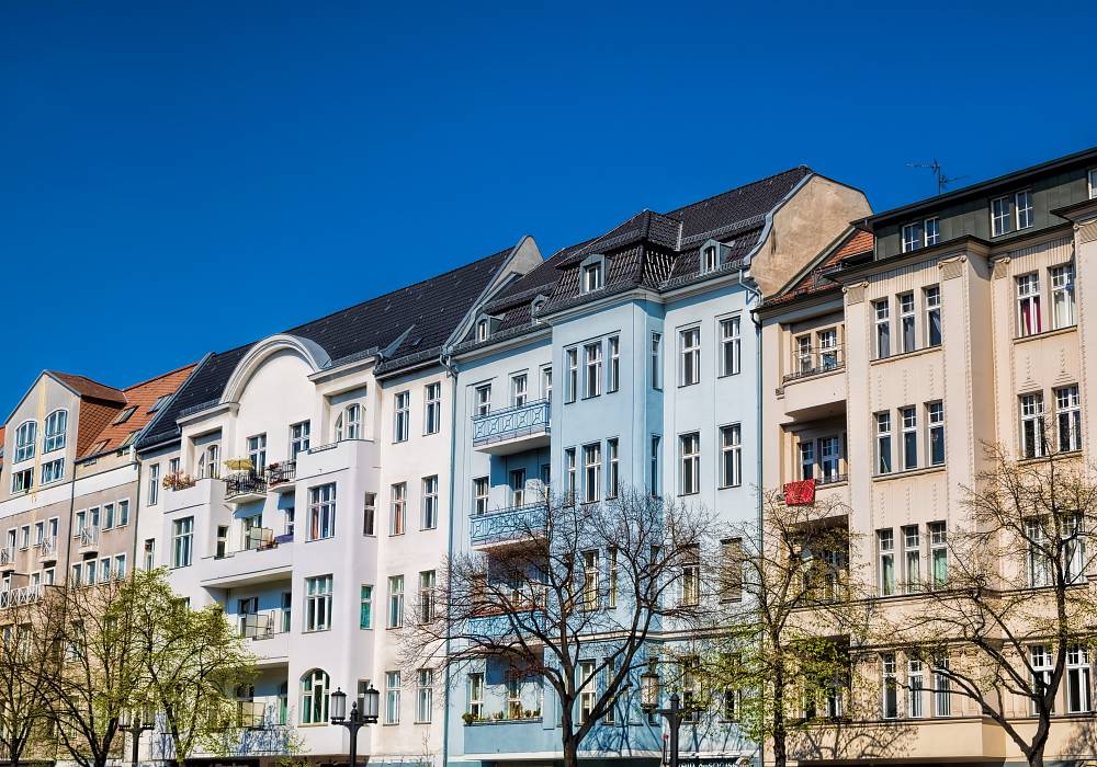 Mehrfamilienhäuser in Berlin mit historischer Fassade bei klarem Himmel