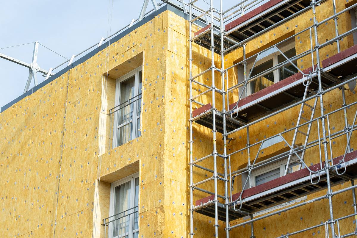 Mehrfamilienhaus mit Gerüst und Dämmmaterial an der Fassade – stellvertretend für energetische Sanierung und Modernisierung.