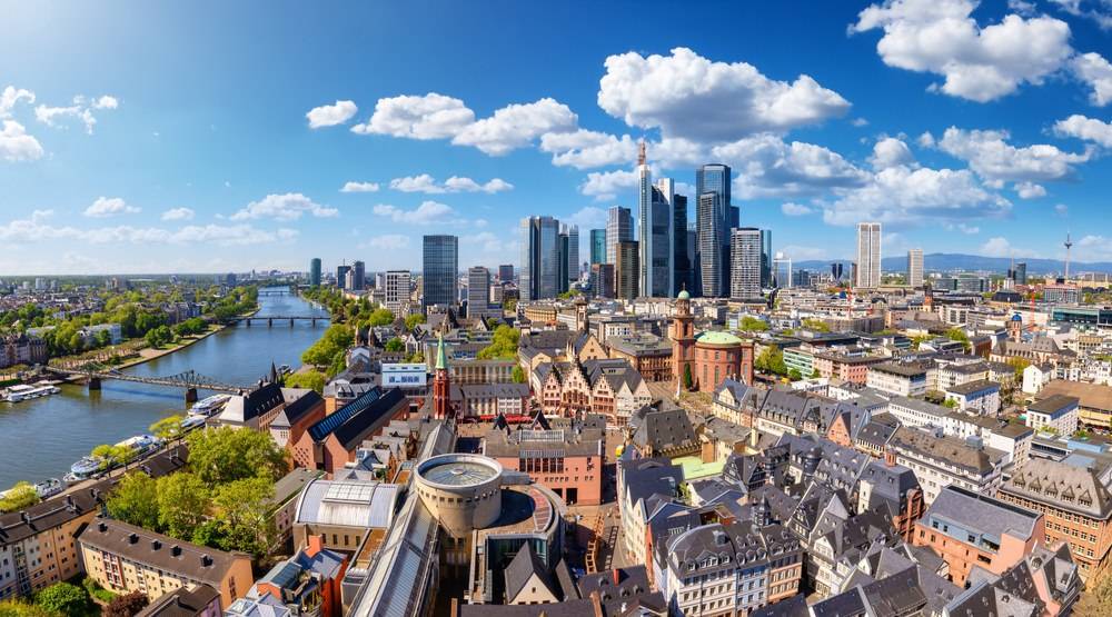Panorama von Frankfurt am Main mit Skyline und Mainufer bei sonnigem Wetter.