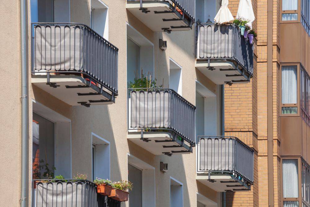 Reihen moderner Wohnhäuser in Hannover mit hellen Fassaden, Balkonen und Blumenkästen.