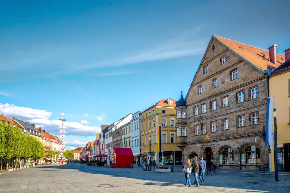 Historische Wohn- und Geschäftshäuser mit warmen Fassadenfarben in der Fußgängerzone von Bayreuth bei Sonnenuntergang