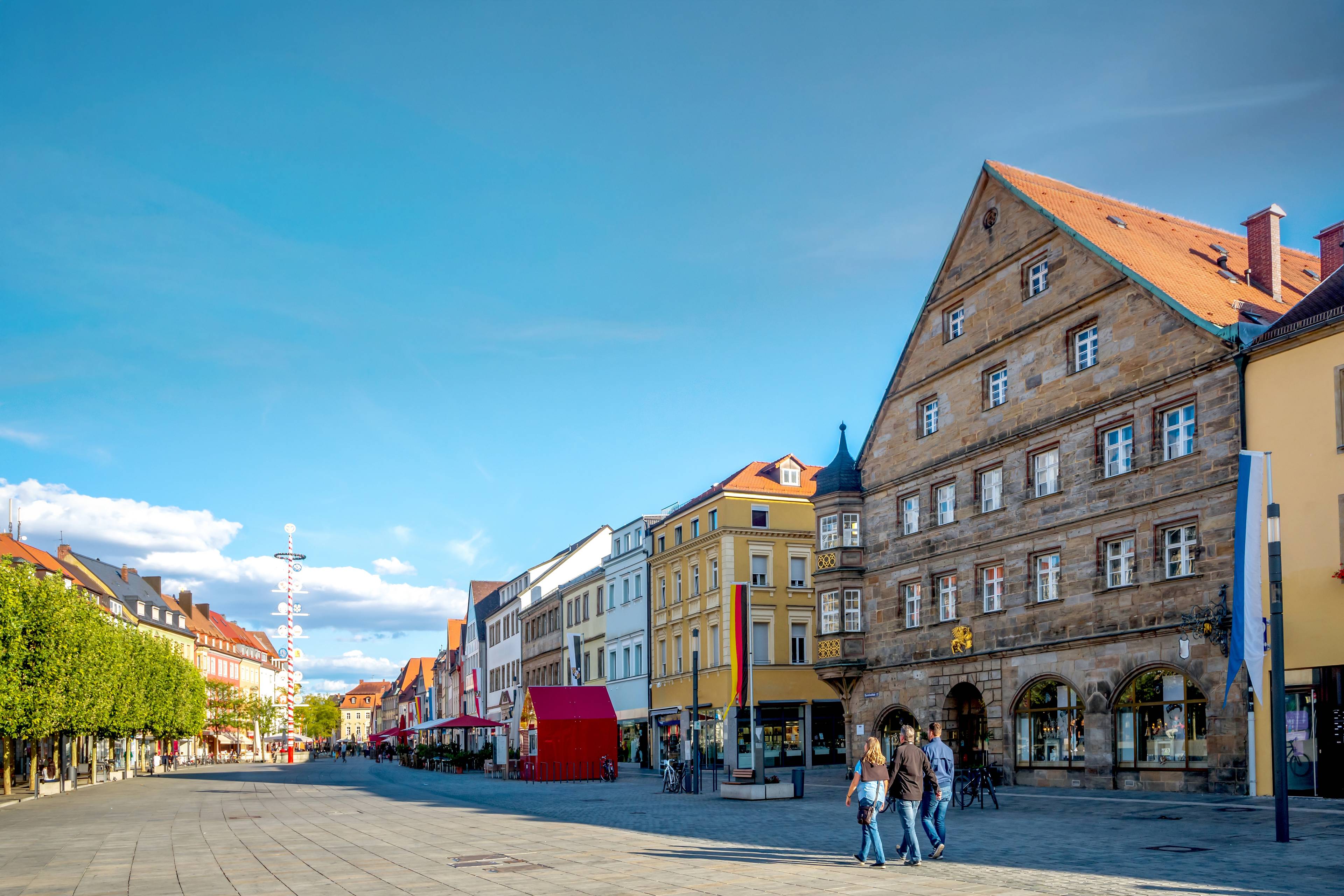 Historische Wohn- und Geschäftshäuser mit warmen Fassadenfarben in der Fußgängerzone von Bayreuth bei Mittag