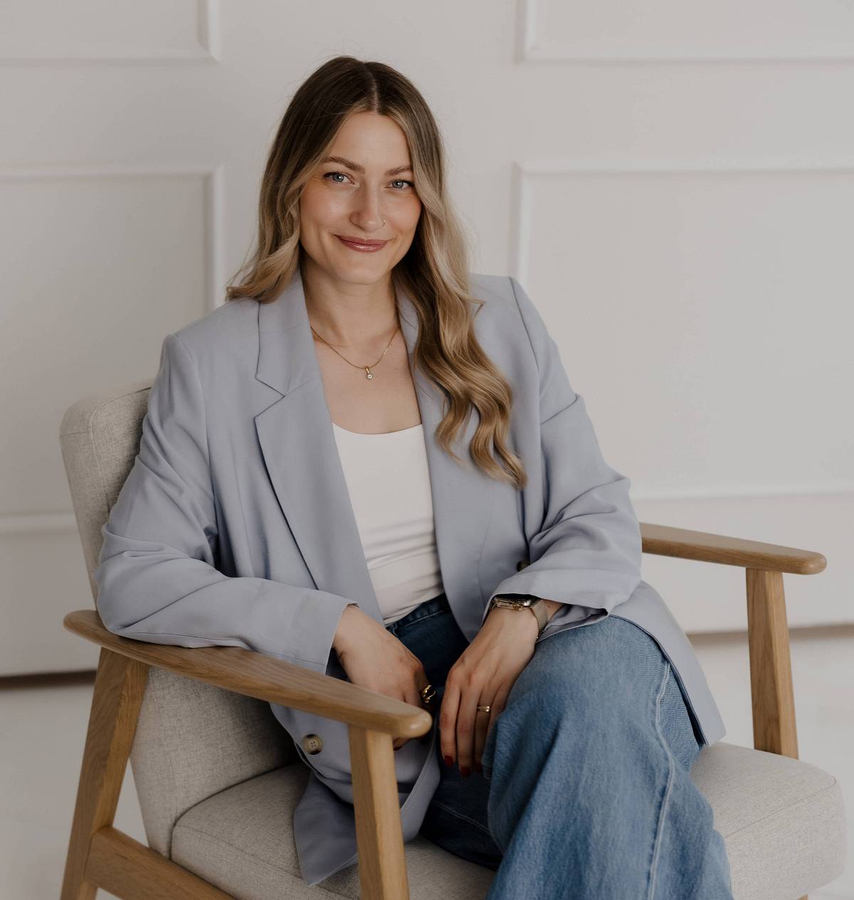 Immobilienberaterin sitzt entspannt im Sessel – persönliche und diskrete Beratung rund um Immobilienverkauf.