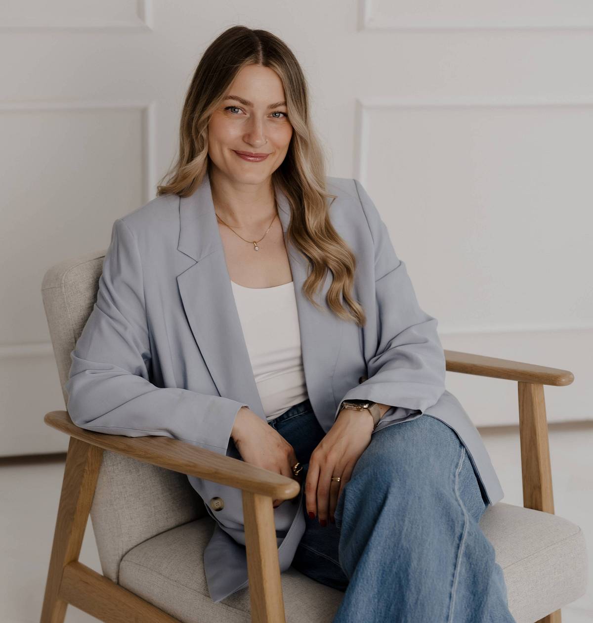 Immobilienberaterin sitzt entspannt im Sessel – persönliche und diskrete Beratung rund um Immobilienverkauf.