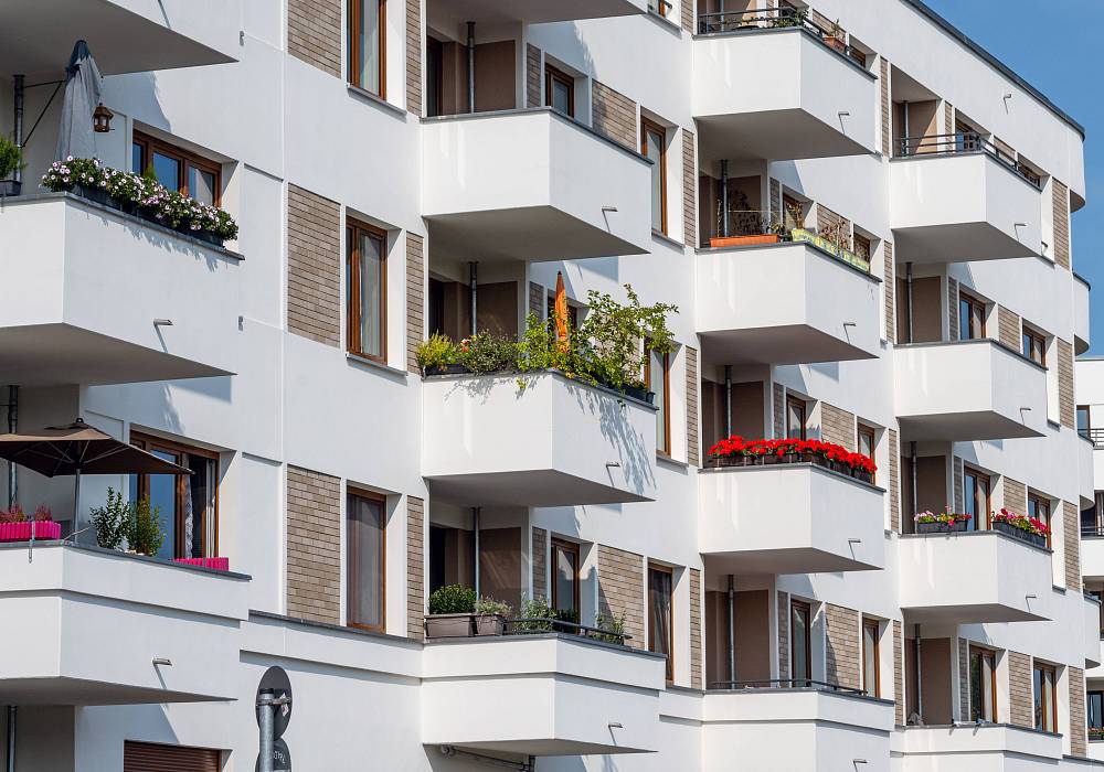 Modernes Mehrfamilienhaus mit weißen Fassaden und Balkonen in Berlin