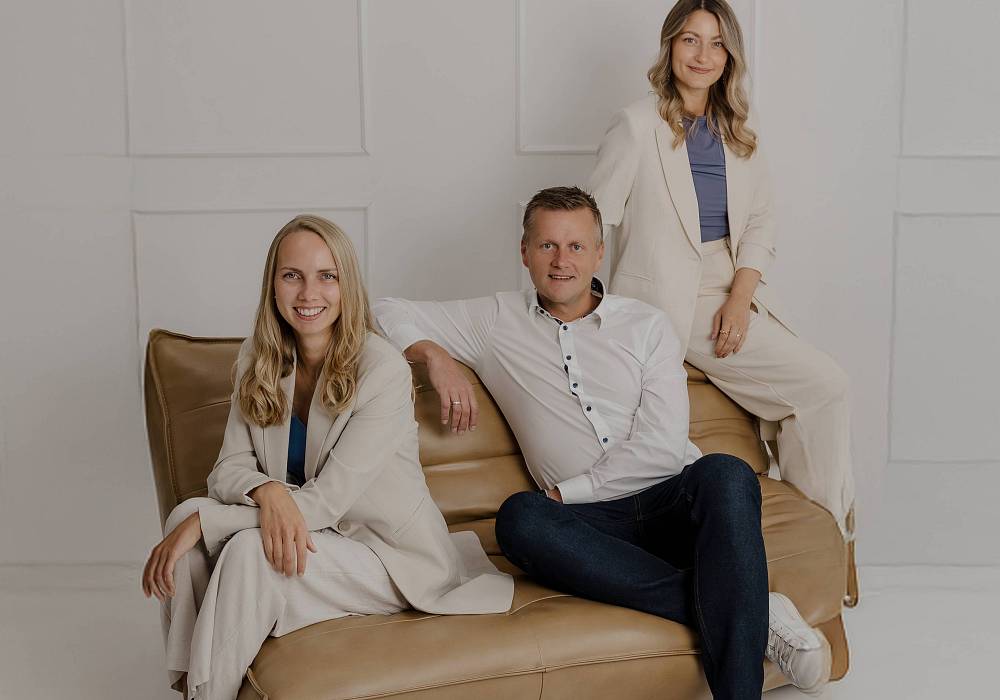 Peter Vogt und Kollegen im modernen Büro, lächelnd in die Kamera