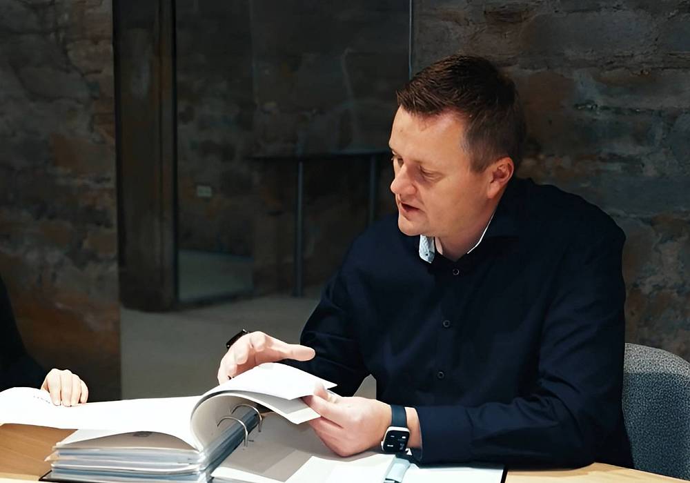 Beratungsgespräch bei einem Mehrfamilienhausmakler – Kunde im Gespräch mit einem Immobilienexperten über Kapitalanlage.