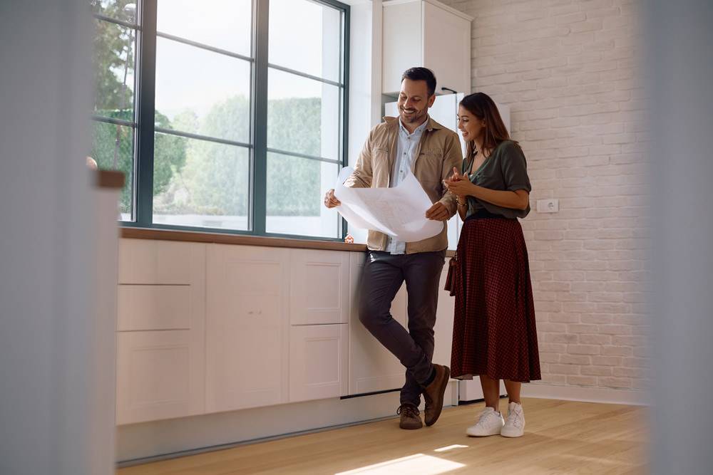 Paar besichtigt eine Wohnung und prüft gemeinsam Unterlagen beim Immobilienkauf in Bayreuth
