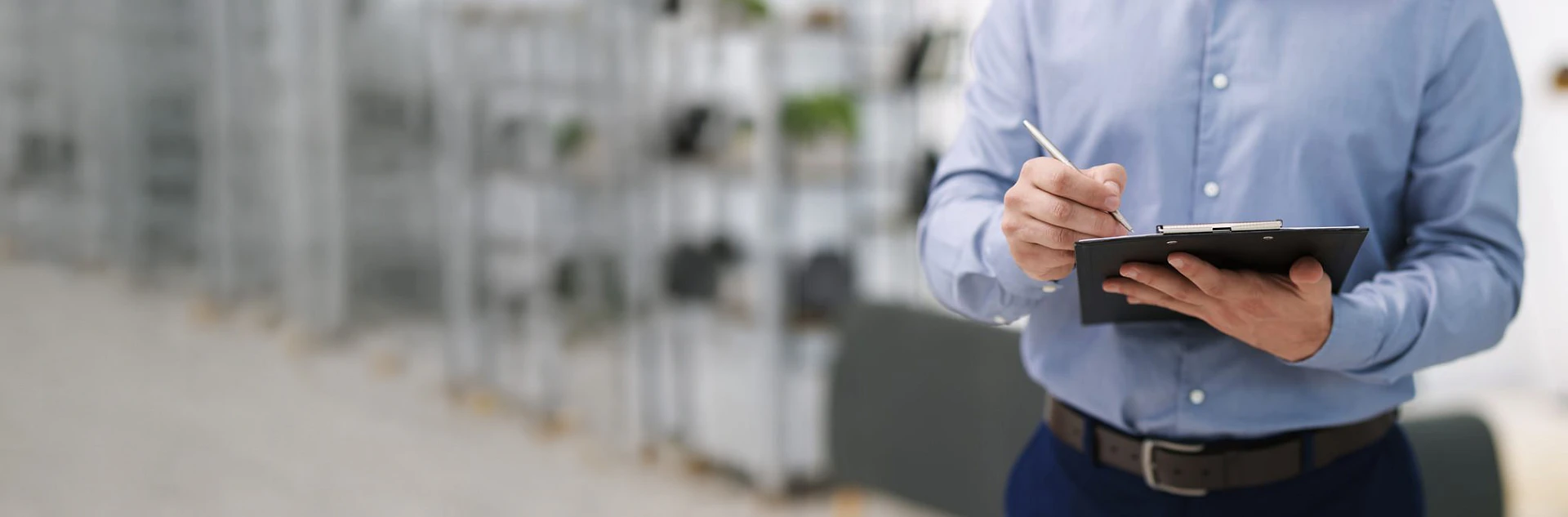Immobilienmakler mit Klemmbrett bei der professionellen Bewertung einer Immobilie
