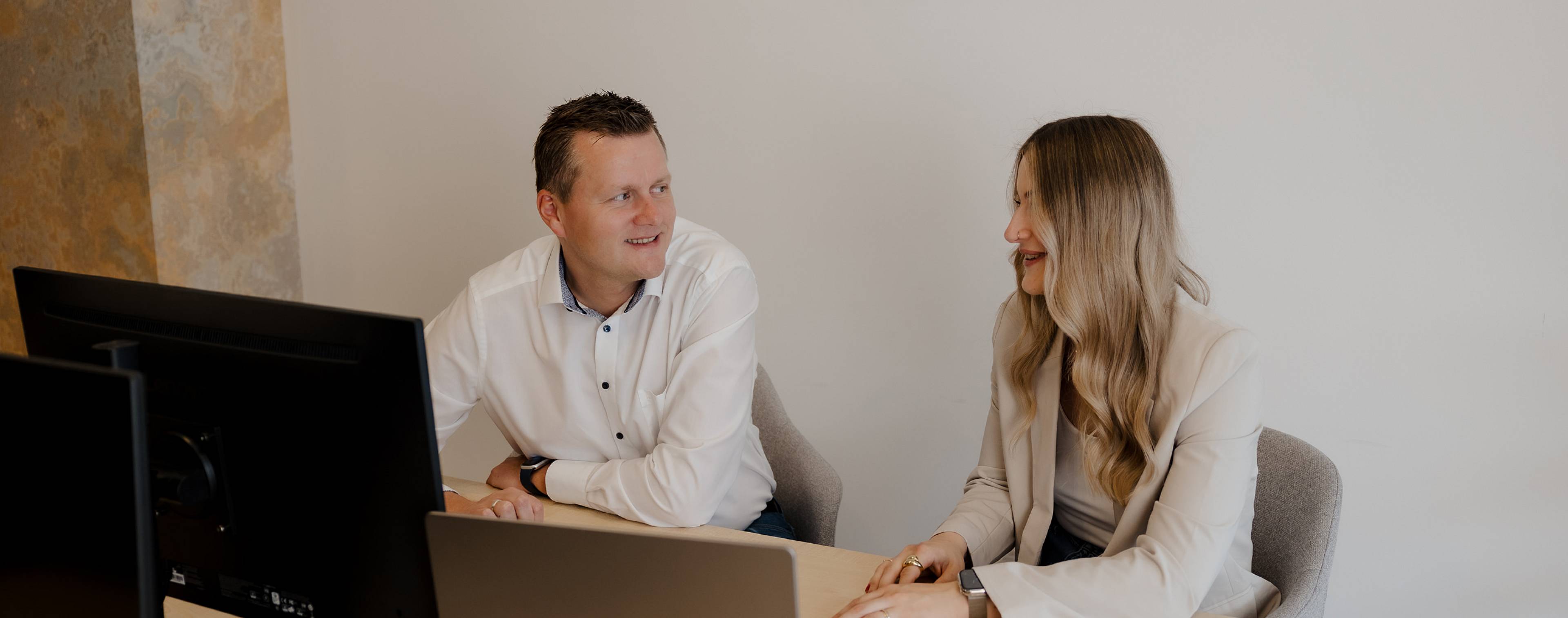 Peter Vogt und Mitarbeiterin im Gespräch vor dem Immobilienbüro – persönliche Beratung vor Ort