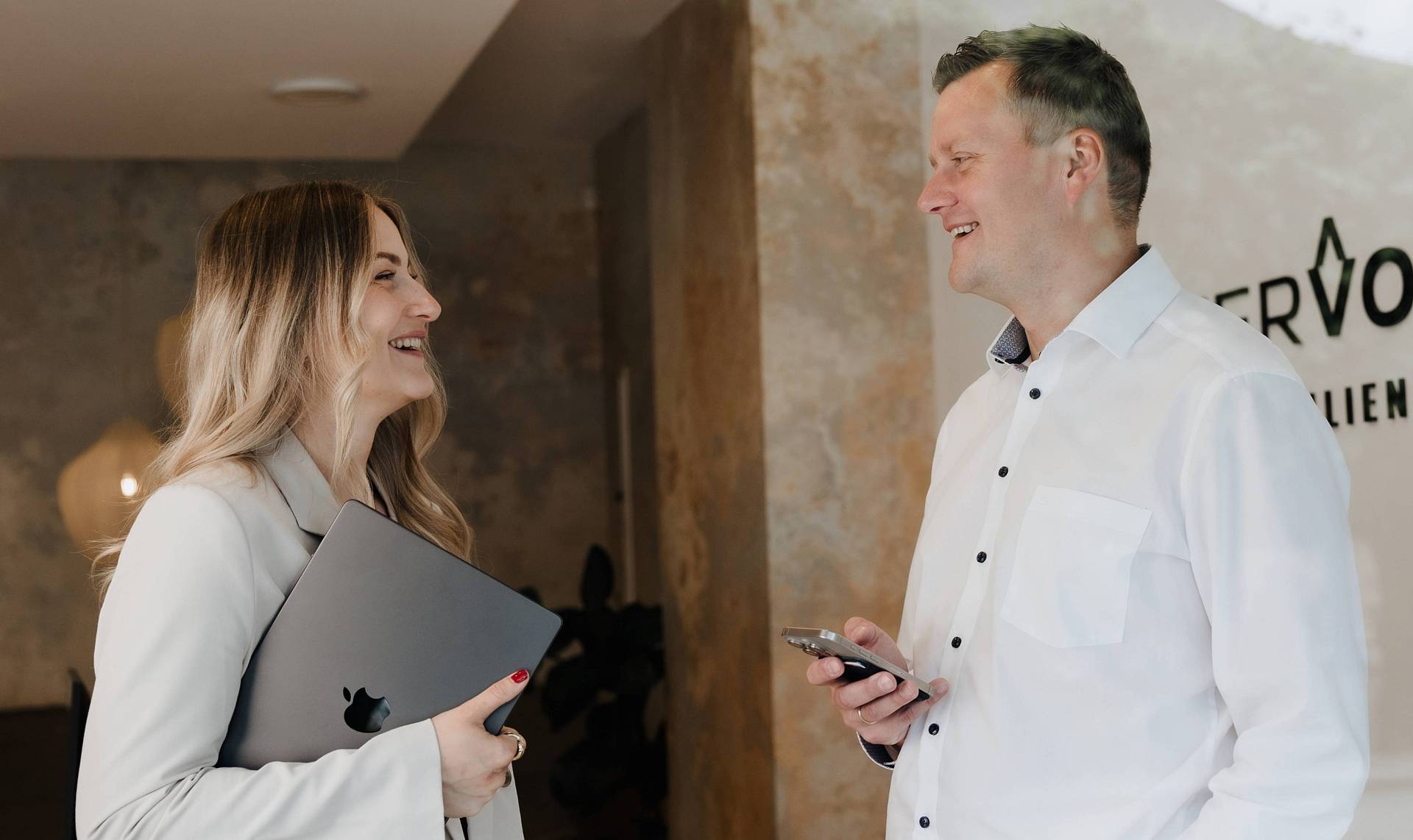 Peter Vogt und Mitarbeiterin im Gespräch vor dem Immobilienbüro – persönliche Beratung vor Ort