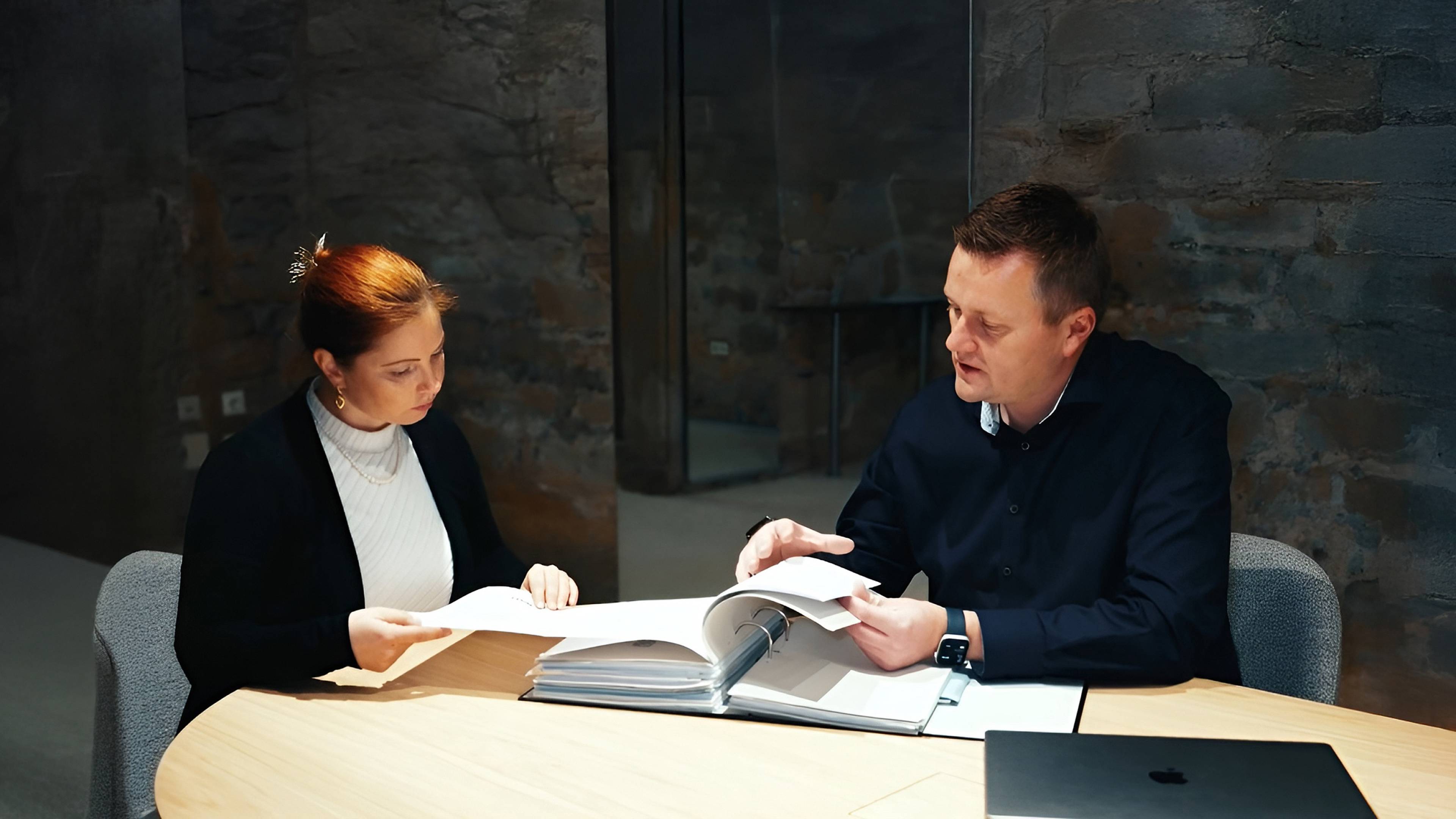 Beratungsgespräch bei einem Mehrfamilienhausmakler – Kunde im Gespräch mit einem Immobilienexperten über Kapitalanlage.