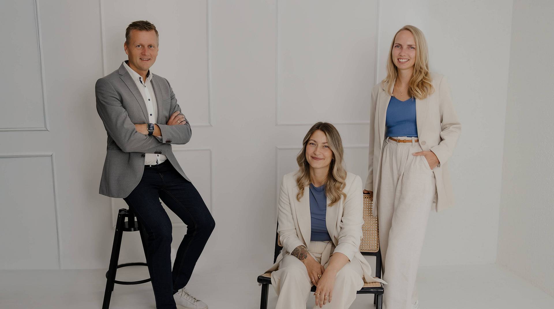 Peter Vogt und Kollegen lächelnd vor weißer Wand – das Team von Peter Vogt stellt sich vor.